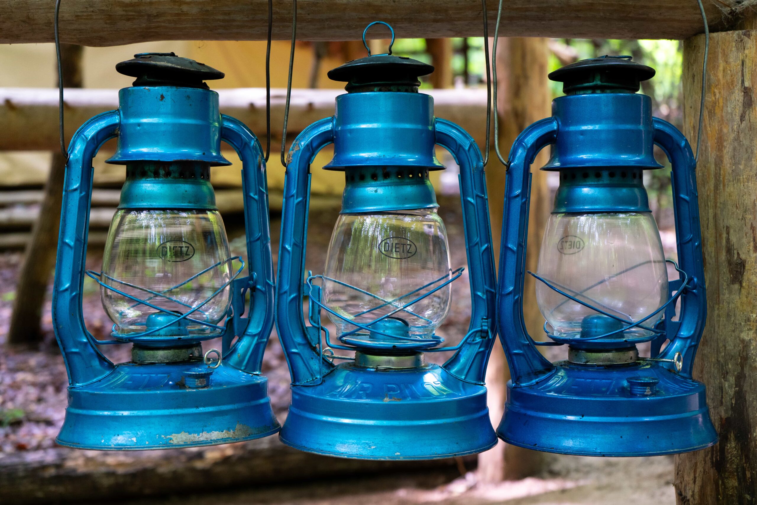 Three blue lanterns hanging in a Fair Play Camp shelter