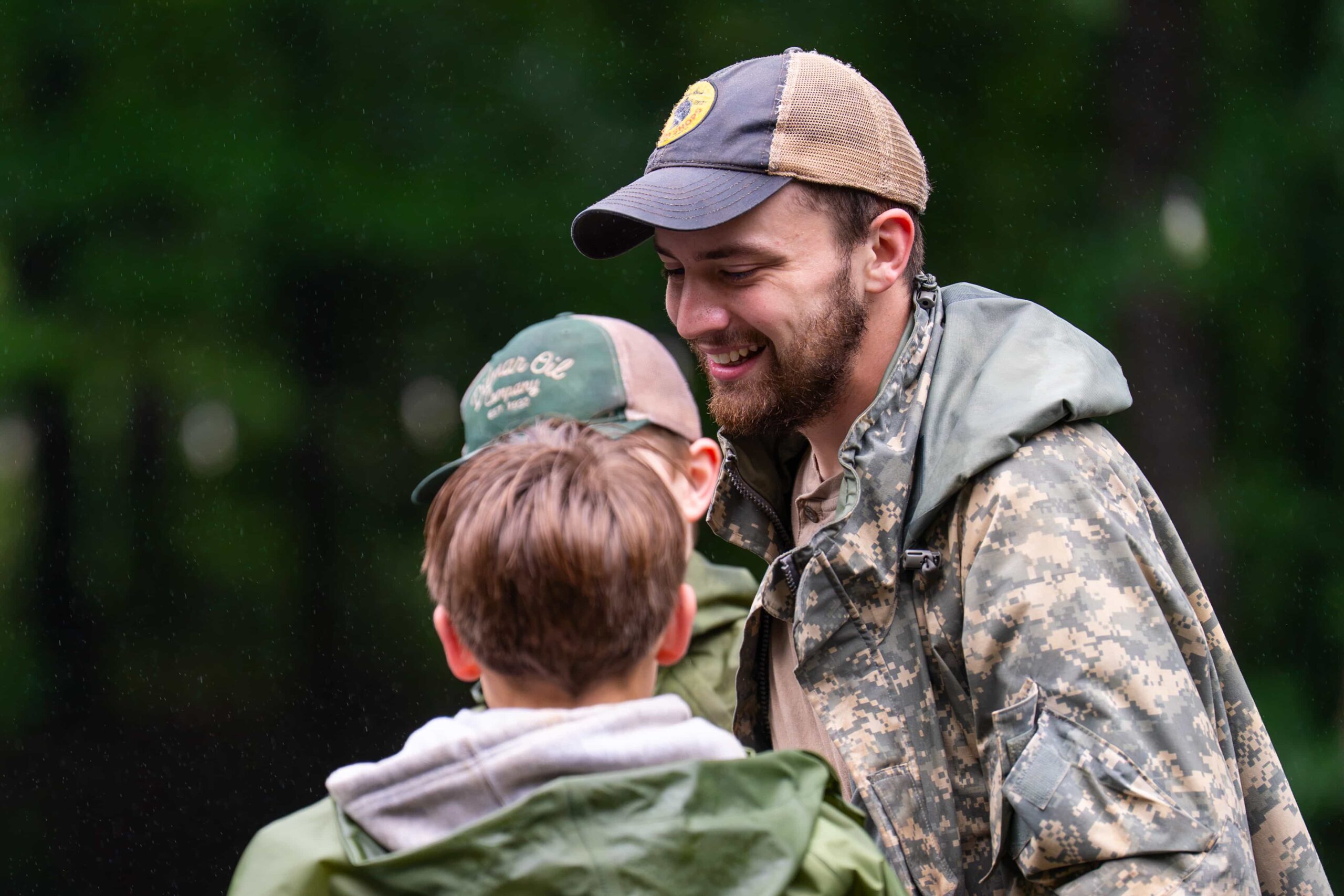 Fair Play Chief talking with boys outdoors in the rain