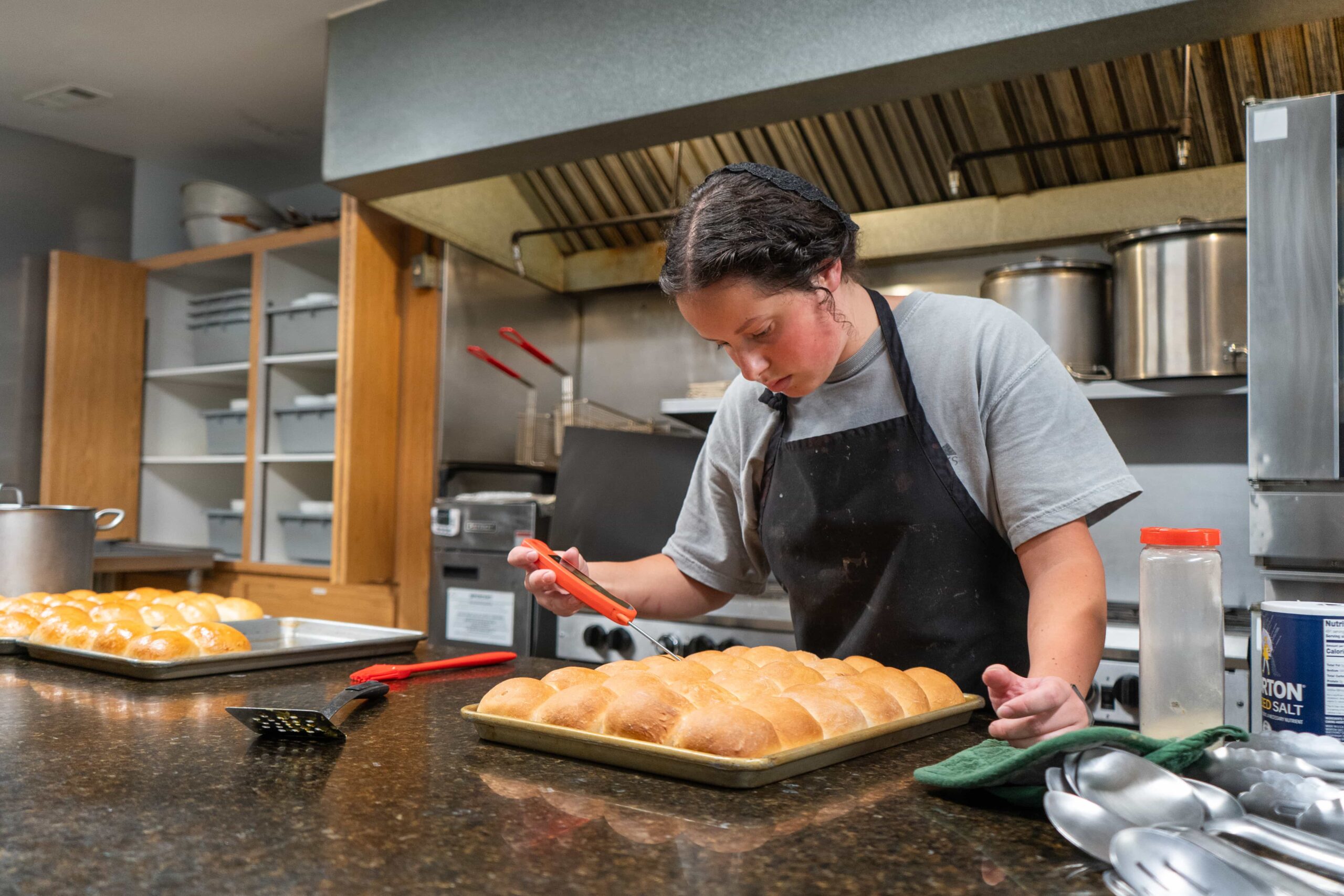 Fair Play Camp cook preparing fresh rolls in the kitchen